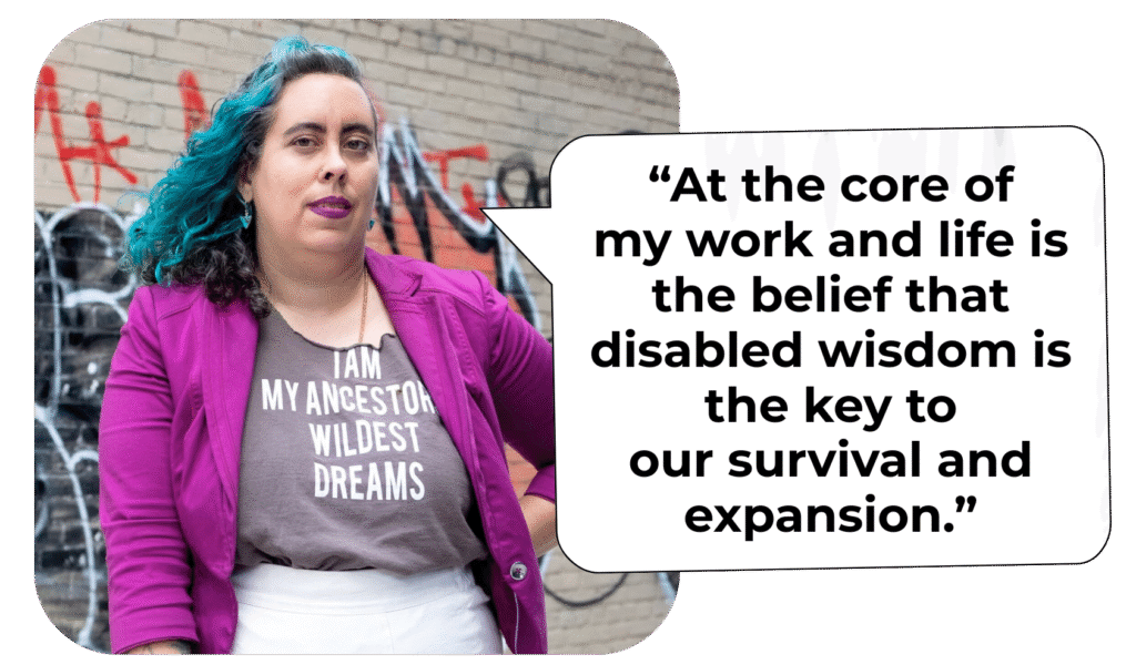 Photo of Leah Lakshmi, a femme of color with curly black hair partially dyed blue, wearing a shirt reading "I am my ancestors' wildest dreams." A speech bubble reads "At the core of my work and life is the belief that disable wisdom is the key to our survival and expansion."